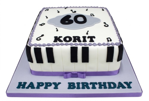 White rectangular cake with piano keys, musical notes, custom age topper, and personalised name.