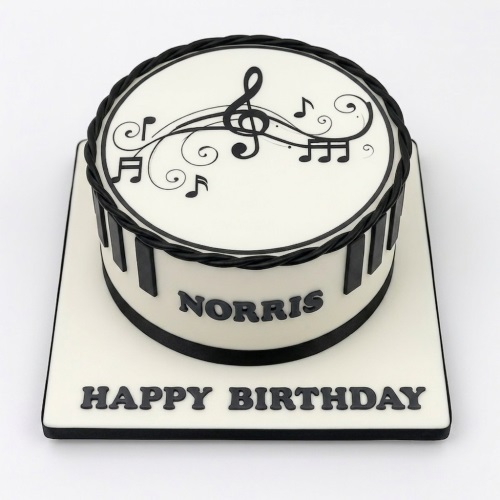 White and black round cake with musical notes, treble clef, and piano keys.