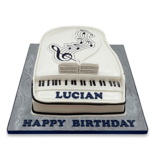 White grand piano shaped birthday cake with black keys, music notes, and a custom message.