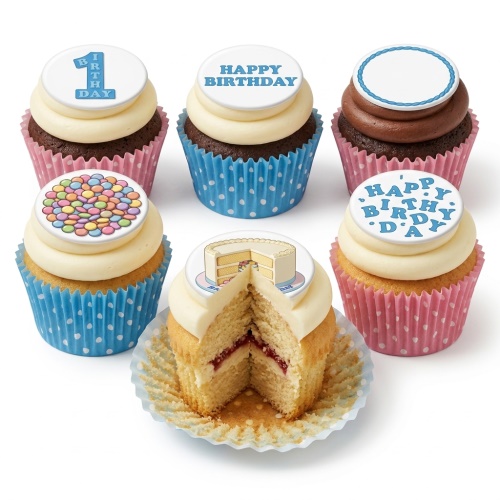 Assortment of birthday cupcakes with '1st Birthday', 'Happy Birthday', candy, and cake slice toppers in pink and blue cases.