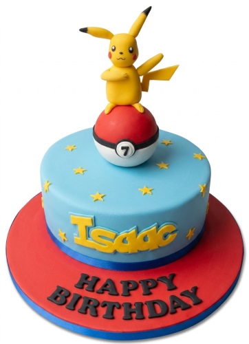 Round blue cake with a Pikachu figurine on a Poké Ball, yellow stars, and a custom name.
