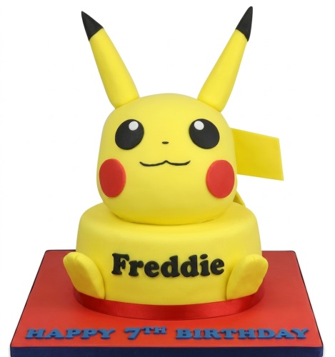 Yellow Pikachu character birthday cake with red cheeks and black ears on a red and blue board.