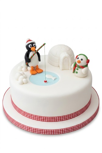 White round cake with fondant penguin, snowman, igloo, and fishing scene.