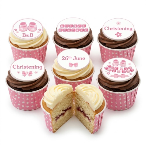 Pink cupcakes with baby booties, building blocks, and Christening toppers.