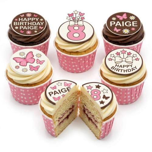 Pink and white cupcakes with butterfly and star toppers in polka dot cases.