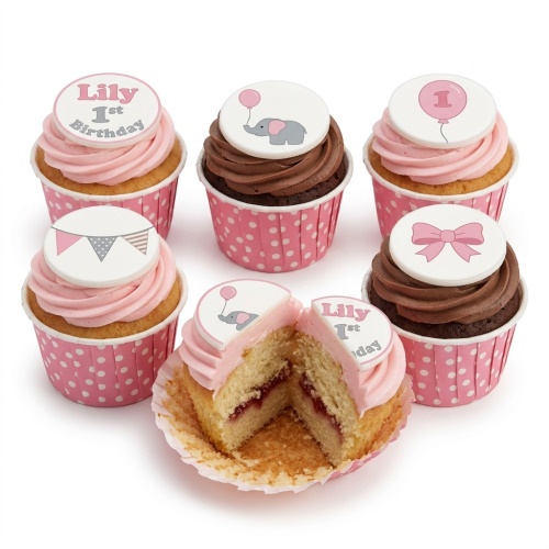 Pink and chocolate cupcakes with 1st birthday toppers, featuring an elephant, balloon, bunting, and bow in pink and grey.