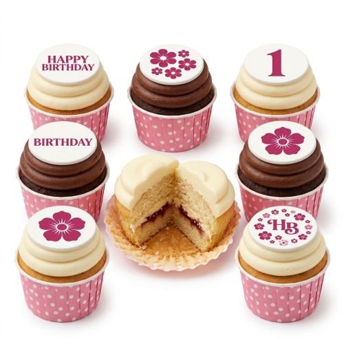 Assortment of floral birthday cupcakes with white and chocolate icing, pink polka dot cases, and custom age/message toppers.
