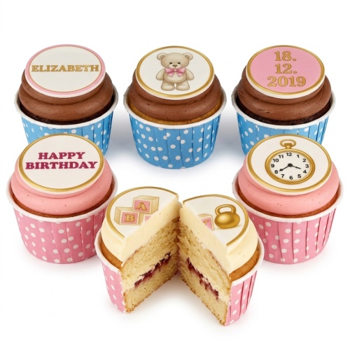 Assortment of baby celebration cupcakes with teddy bear, baby blocks, and pocket watch toppers.