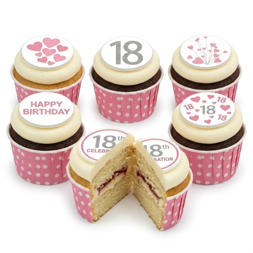 Six cupcakes with white frosting, pink polka dot cases, heart-themed toppers, and a custom age topper.