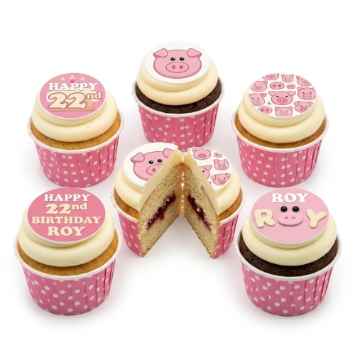 Assortment of pig theme birthday cupcakes with custom age and name toppers in pink polka dot cases.