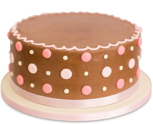 Round brown cake with pink and white polka dots, scalloped pink border, and pink ribbon.