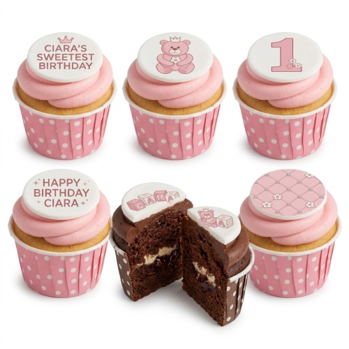 Pink and white cupcakes with teddy bear, number one, and building block toppers for a girl's first birthday.