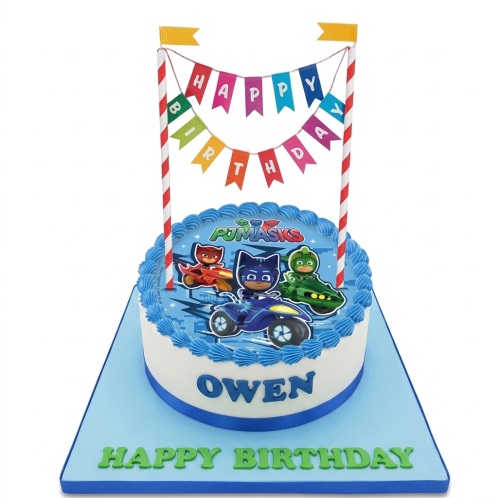 Round white and blue PJ Masks birthday cake with Catboy, Owlette, Gekko, and 'Happy Birthday' bunting topper.