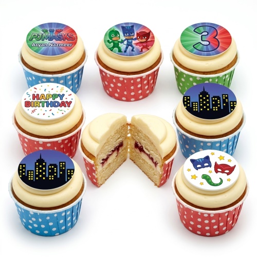 Assortment of PJ Masks themed birthday cupcakes with character toppers, cityscape, and custom age.