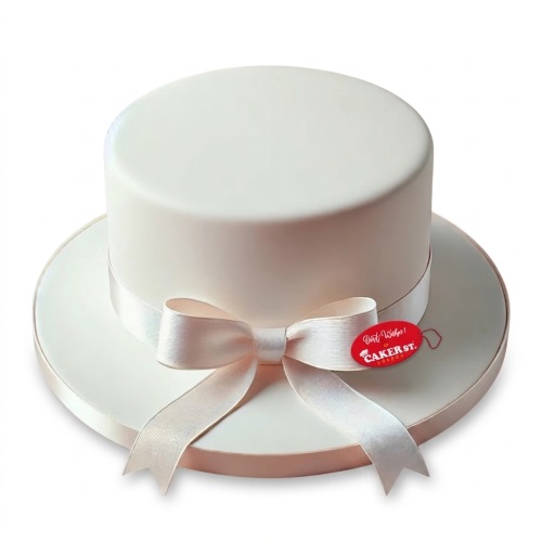 White top hat shaped birthday cake with a satin ribbon bow
