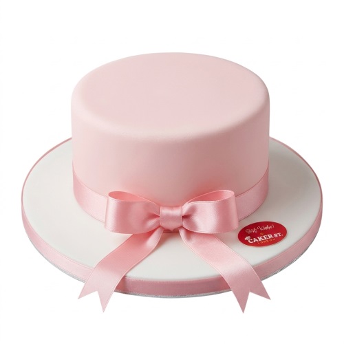 Pink round birthday cake with a satin ribbon and bow.