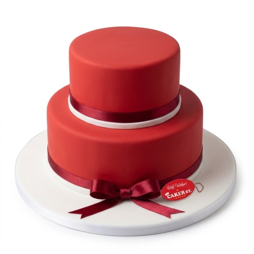 Two-tier round red fondant cake with red and white satin ribbons and bow.