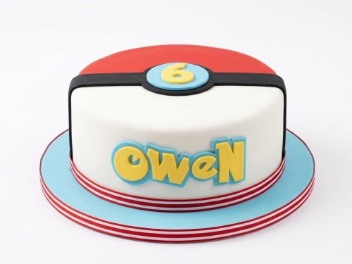 Round Poké Ball themed birthday cake with red and white fondant, black band, and custom age number.