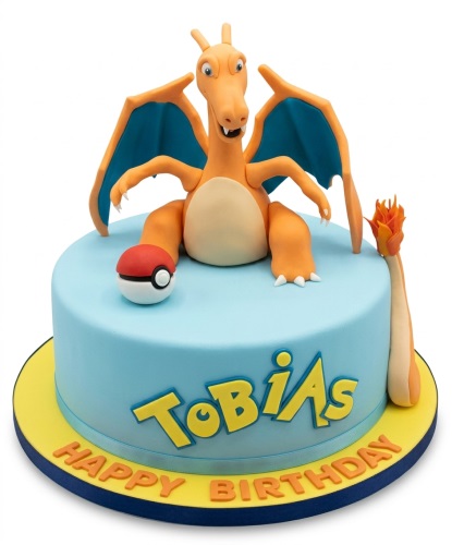 Round blue birthday cake with a 3D orange Charizard figure, a Pokeball, and a flame decoration.