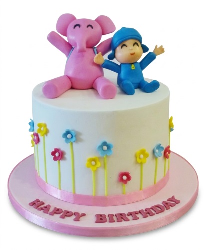 White round birthday cake with Pocoyo and Elly figures, colourful flowers, and a 'Happy Birthday' message.
