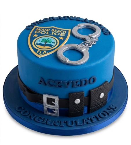 Blue police theme cake with a police emblem, silver handcuffs, and a uniform belt design.