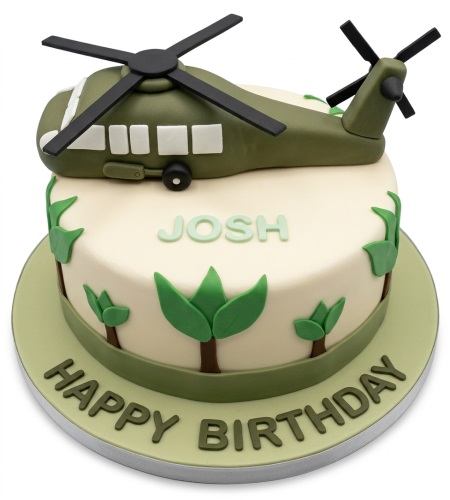 Round cream birthday cake with a green 3D helicopter topper and green jungle leaves. Personalised name and "Happy Birthday" message on board.