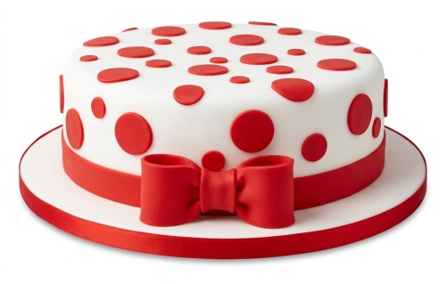 Round white cake with red polka dots and a red bow decoration on a white cake board.