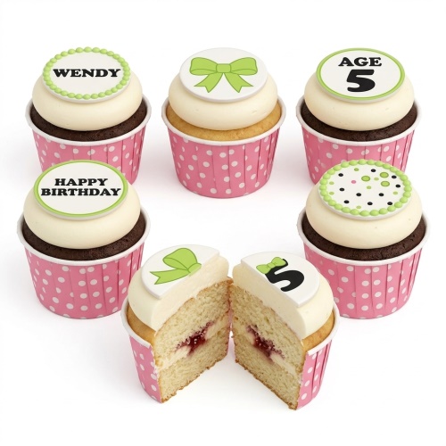 Pink polka dot cupcakes with white frosting, green bows, and custom age/message toppers.