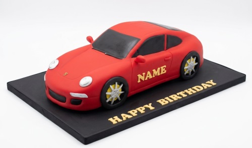 Red 3D sports car shaped birthday cake with black board and gold 'Happy Birthday' message.