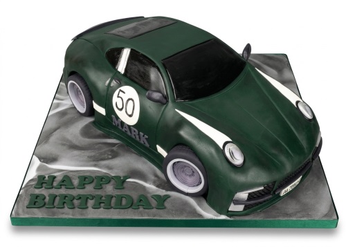Green sports car birthday cake with white racing stripes and custom age on a grey board.