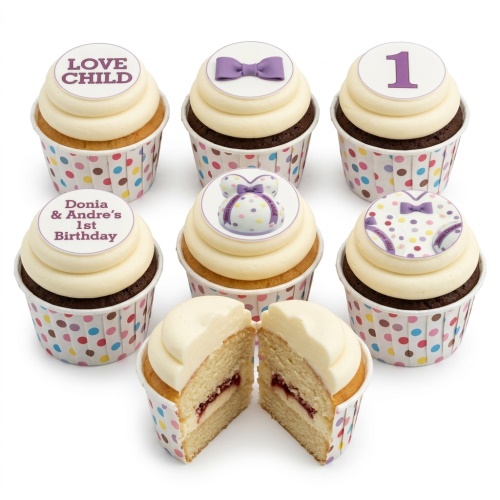 Baby shower cupcakes with white frosting, polka dot wrappers, and baby-themed edible toppers including a bow tie, pregnant belly, and number one.