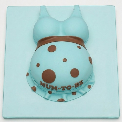3D sculpted baby shower cake in light blue with brown polka dots and 'MUM-TO-BE' message.