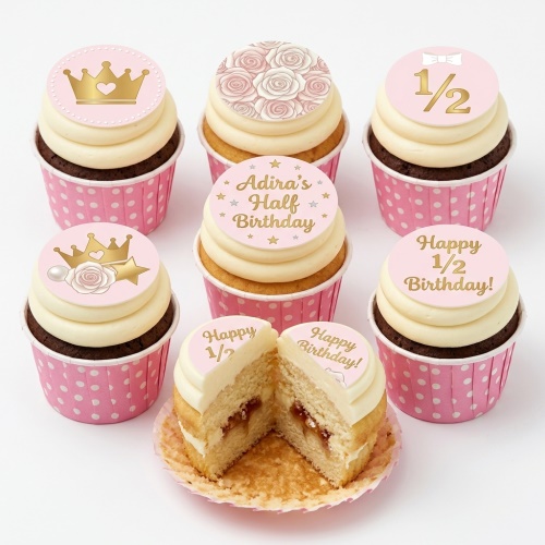Pink and gold half birthday cupcakes with crowns, roses, and '1/2 Birthday' toppers.