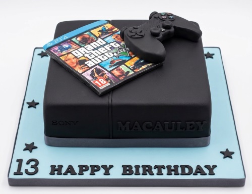 Black PlayStation console cake with controller, Grand Theft Auto game, custom age, and Happy Birthday message.