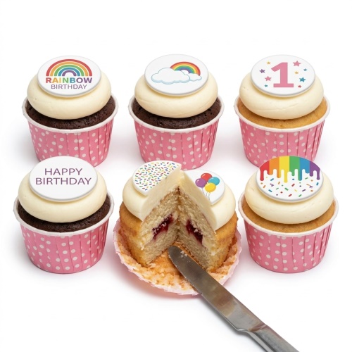 Set of six cupcakes with white icing and colourful rainbow, balloon, and sprinkle toppers, some with 'Happy Birthday' and 'Rainbow Birthday' messages, and a '1' age topper.