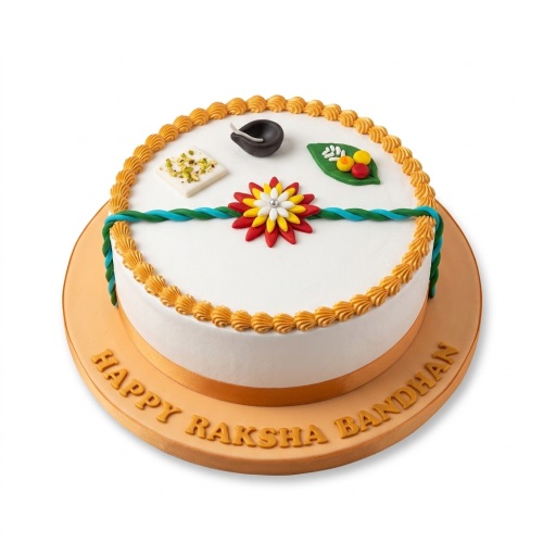 Round white cake with Raksha Bandhan decorations including a rakhi, diya, and sweet.