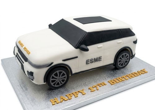 White 3D Range Rover car shaped birthday cake on a silver board with custom age and name.