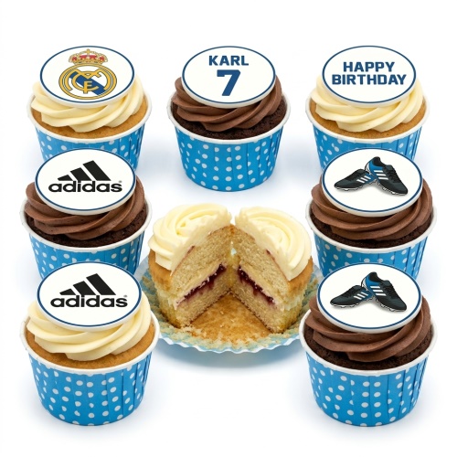 Assortment of football-themed cupcakes with Real Madrid, Adidas, and football boot toppers on blue polka dot wrappers.