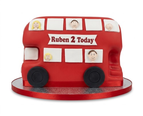 Red double-decker bus birthday cake with cartoon faces in windows and a custom message banner.