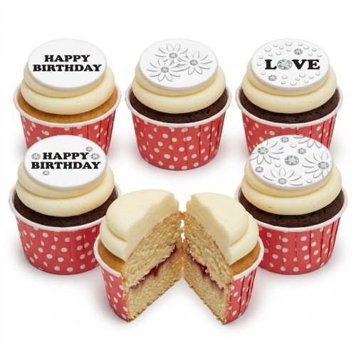Cupcakes with white icing, red polka dot wrappers, and white toppers featuring floral designs, 'Happy Birthday', and 'Love' messages with sparkle accents.
