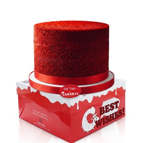 Vibrant red round birthday cake with a matching red ribbon on a white cake board.