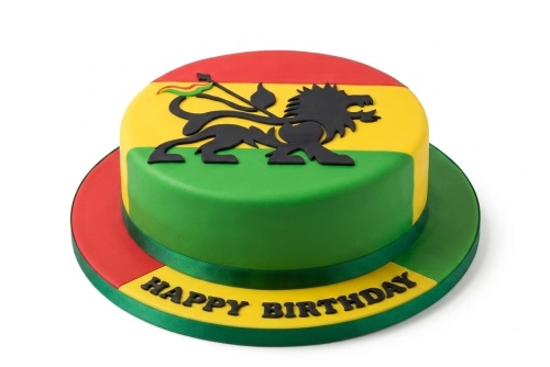 Round reggae themed birthday cake with Lion of Judah and "Happy Birthday" message.