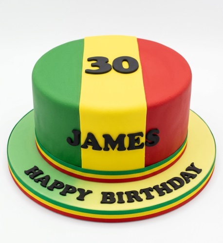 Round reggae theme birthday cake with green, yellow, red stripes, custom age, and name.