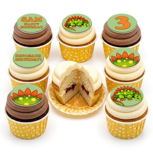 Assortment of dinosaur-themed birthday cupcakes with custom age and message toppers, in yellow polka dot cases.