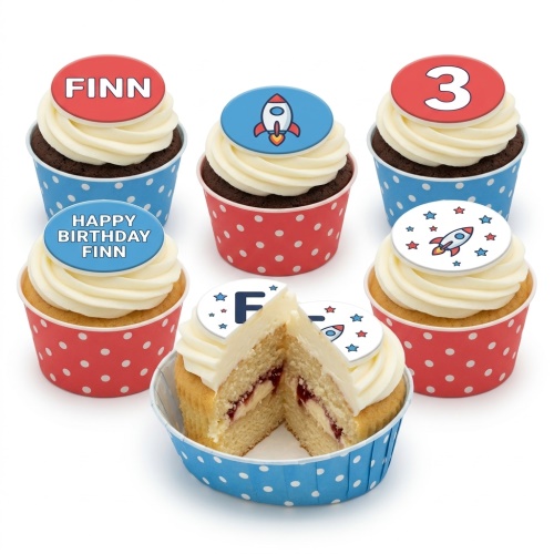 Rocket themed birthday cupcakes with custom age and name toppers in red and blue polka dot cases.