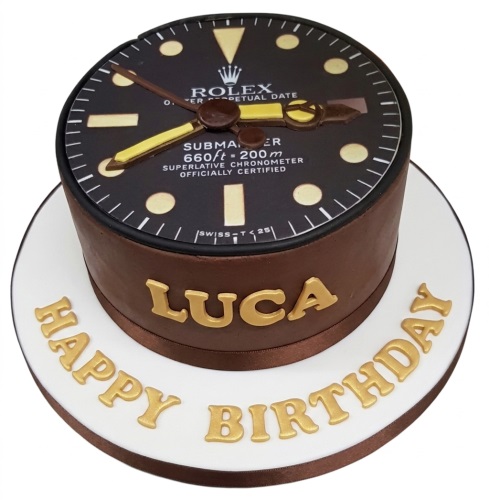 Round brown cake with an edible Rolex watch dial on top and gold "Happy Birthday" text.