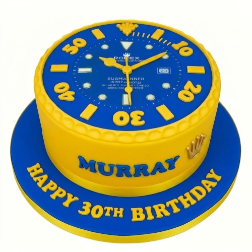 Round blue and yellow watch theme birthday cake with a Rolex-style watch face on top and a golden crown emblem.