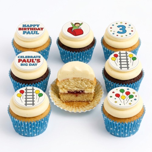 Assortment of kids birthday cupcakes with sports, train, and balloon toppers, featuring a custom age.