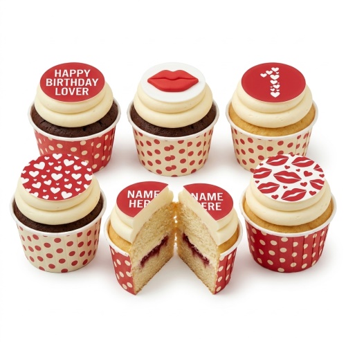 Close-up of six cupcakes with red and white polka dot wrappers. Toppers feature red lips, white hearts, and 'Happy Birthday Lover' text. One cupcake is cut open revealing jam filling.