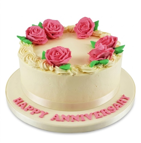 Round cream anniversary cake with pink piped roses and green leaves, 'Happy Anniversary' message.